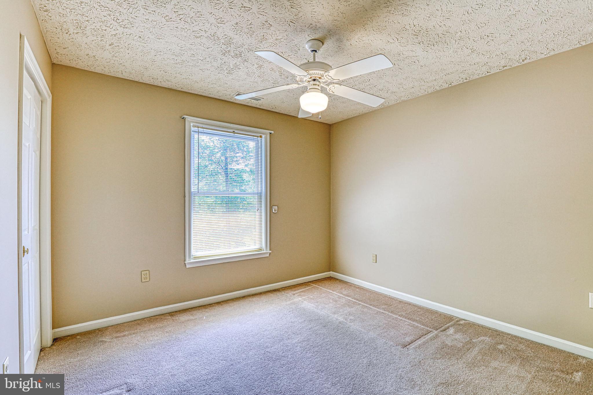 8235 Quarterfield Road Severn, MD 21144 - Photo 22 of 34 an empty room with a window and a fan