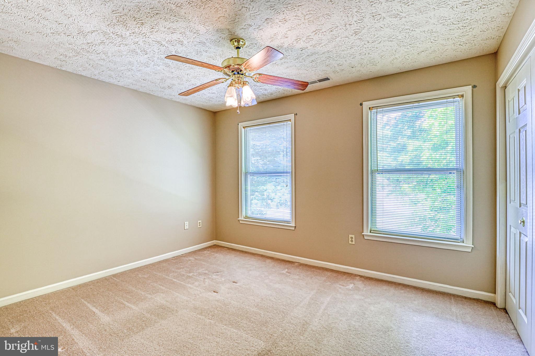 8235 Quarterfield Road Severn, MD 21144 - Photo 23 of 34 an empty room with windows and fan