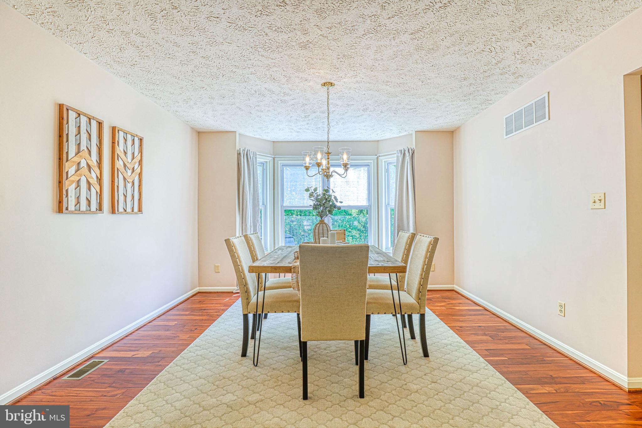8235 Quarterfield Road Severn, MD 21144 - Photo 6 of 34 a dining room with furniture a chandelier and wooden floor