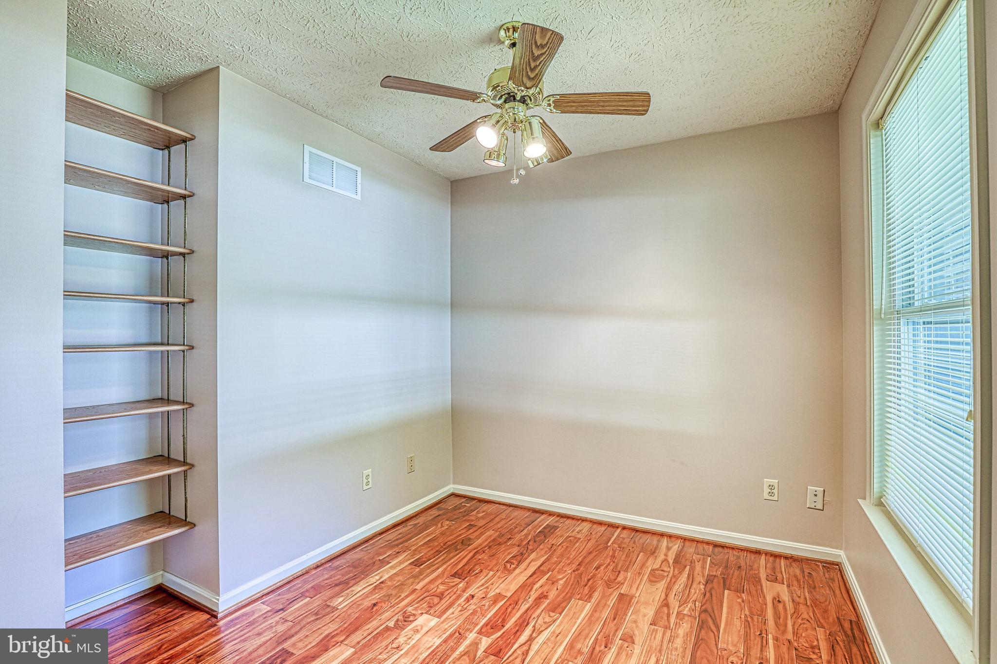 8235 Quarterfield Road Severn, MD 21144 - Photo 8 of 34 a view of an empty room with a window and wooden floor