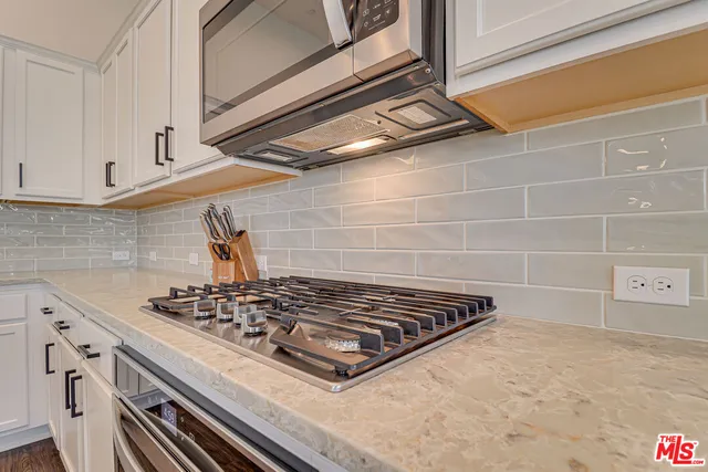 a stove top oven sitting inside of a kitchen