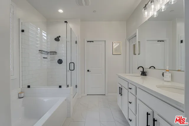 a spacious bathroom with a tub sink shower and mirror