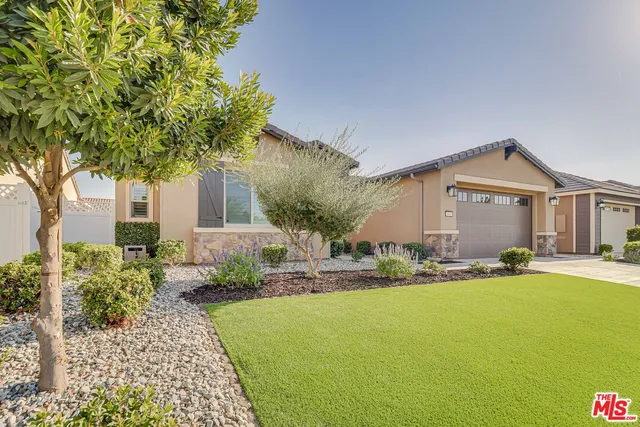 a front view of a house with a yard and trees