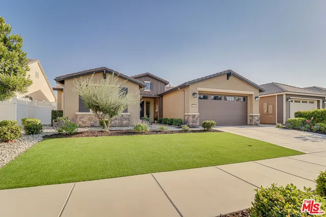 a front view of a house with a garden and plants