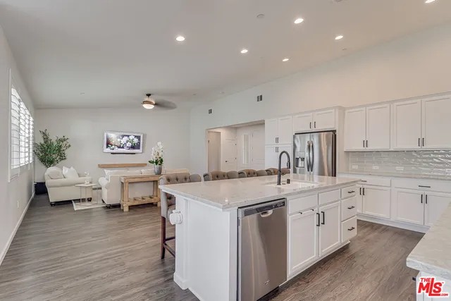 a kitchen that has a lot of cabinets in it and wooden floor