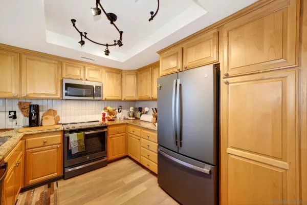 a kitchen with stainless steel appliances granite countertop a refrigerator stove microwave and sink