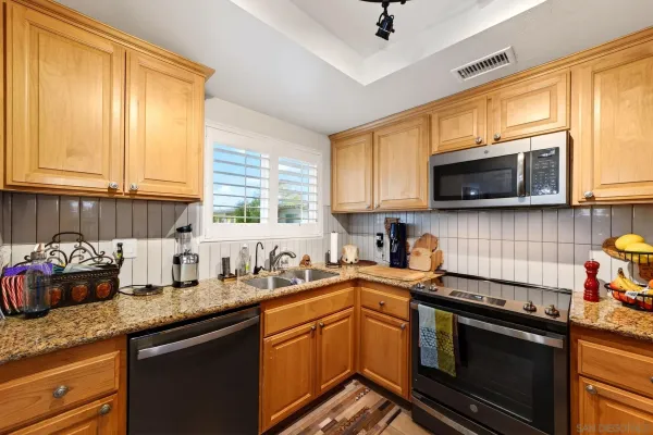 a kitchen with stainless steel appliances granite countertop a sink a stove a microwave and cabinets
