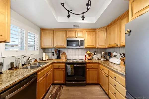 a kitchen with granite countertop a sink and a stove top oven