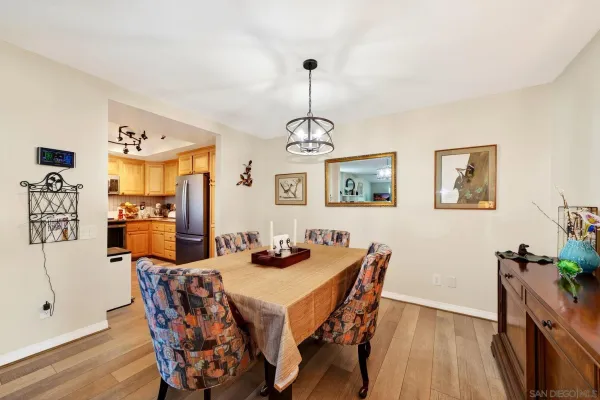 a dining room with furniture a chandelier and wooden floor