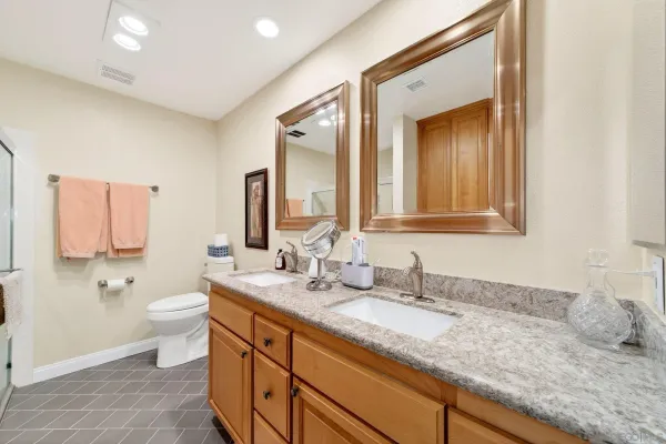 a bathroom with a granite countertop sink mirror and toilet