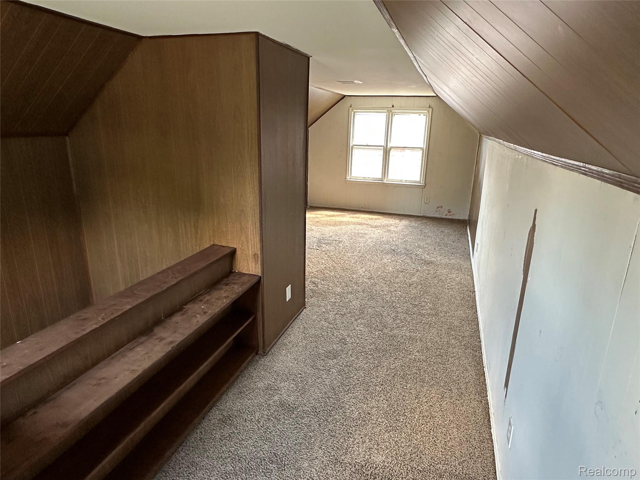 27366 Freda Street Inkster, MI 48141 - Photo 8 of 14 Built-in shelving, paneled walls, and sloped ceiling