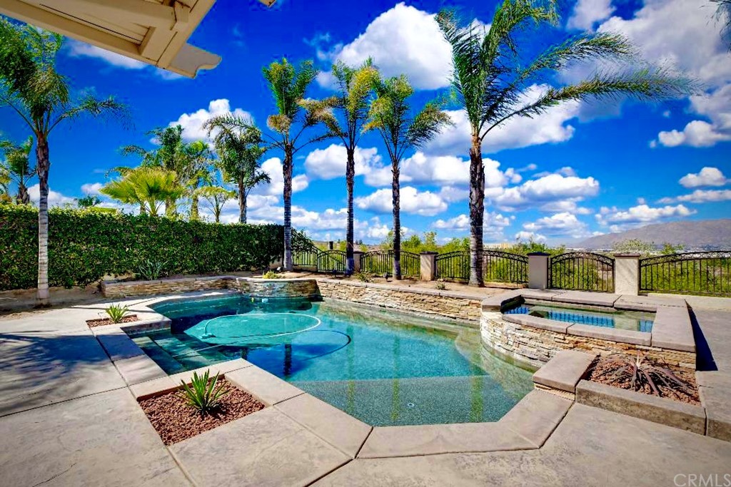 a view of a swimming pool with lounge chairs in patio