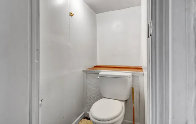 a white toilet sitting next to a shower curtain
