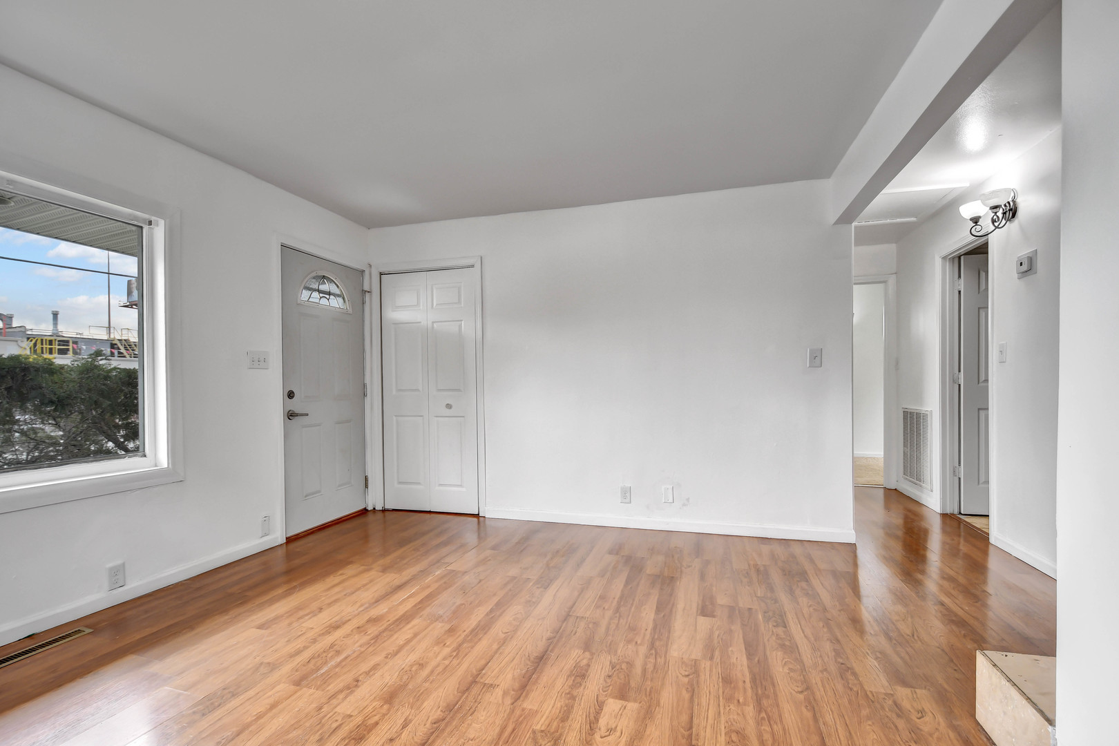 2950 Bernice Road Lansing, IL 60438 - Photo 2 of 16 a view of an empty room with wooden floor and a window