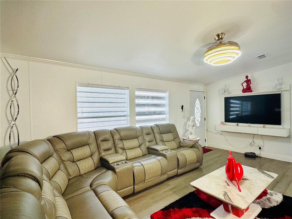 18304 Cedarhurst Road Orlando, FL 32820 - Photo 11 of 24 a living room with furniture and a flat screen tv