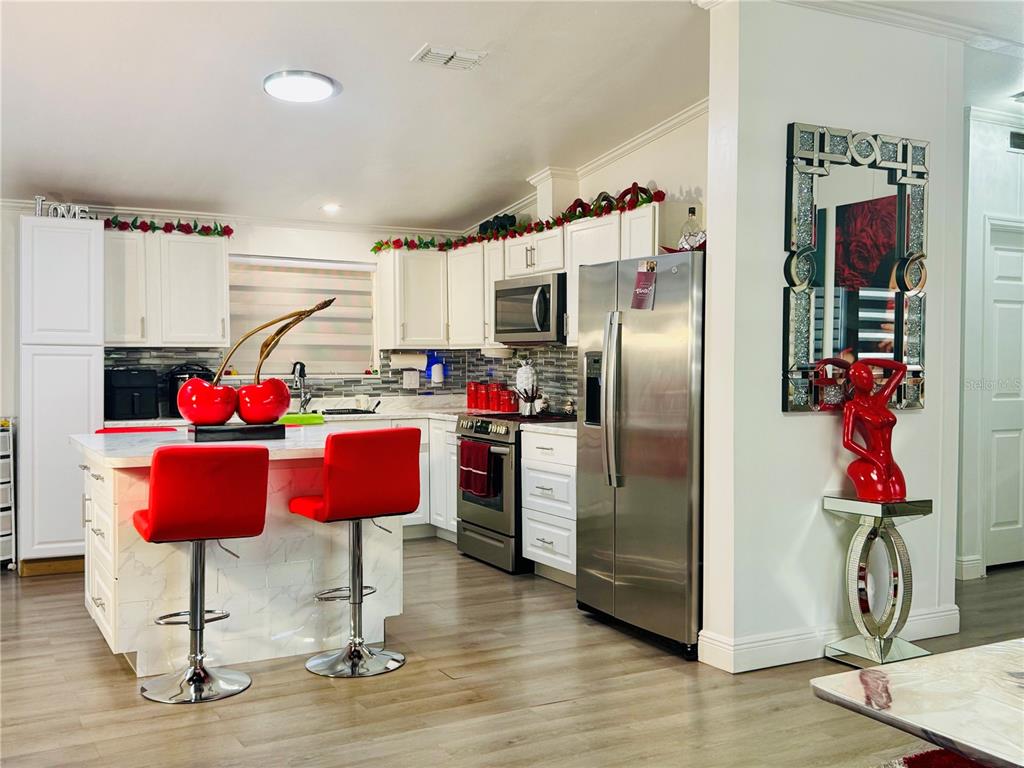 18304 Cedarhurst Road Orlando, FL 32820 - Photo 5 of 24 a kitchen with stainless steel appliances granite countertop a refrigerator and a stove