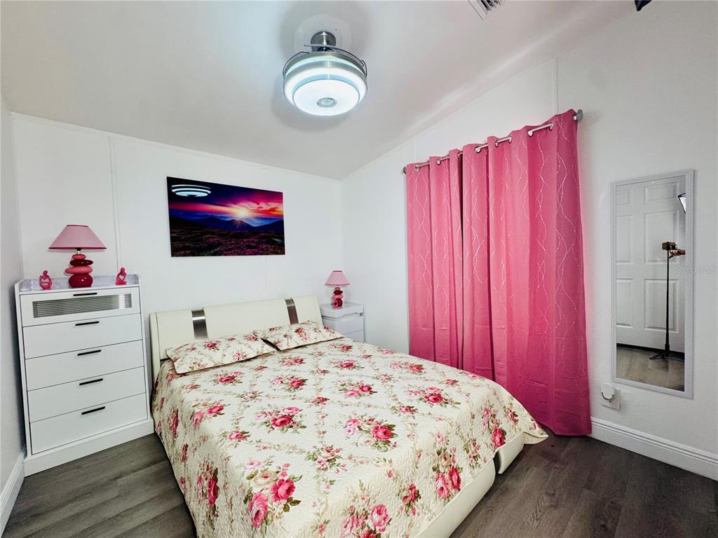 18304 Cedarhurst Road Orlando, FL 32820 - Photo 6 of 24 a bedroom with a bed and a flat screen tv