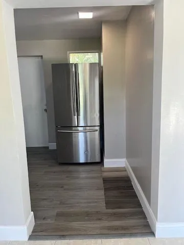 a view of a refrigerator in kitchen and wooden floor