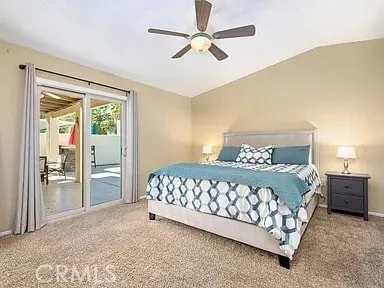 a bedroom with a large bed and a chandelier fan