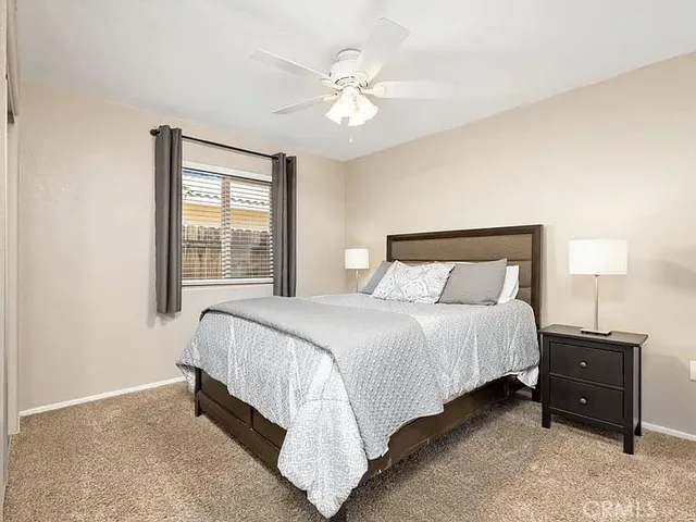 a bedroom with a bed and a ceiling fan
