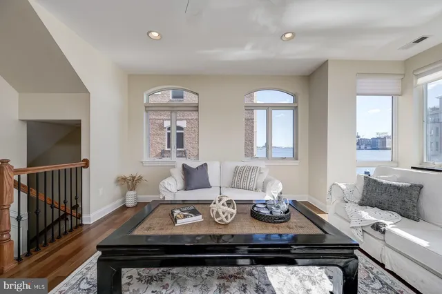 a large dining hall with stainless steel appliances granite countertop a stove a sink a dining table and chairs with wooden floor