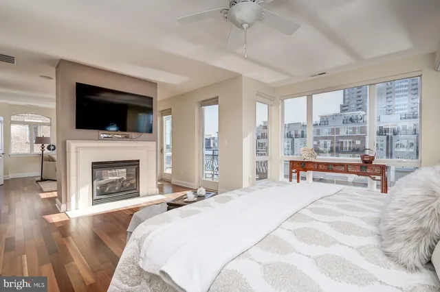 a bathroom with a granite countertop sink a large mirror a toilet and a window