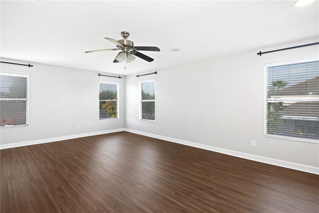 2069 Nerva Road Winter Garden, FL 34787 - Photo 28 of 41 an empty room with wooden floor ceiling fan and windows