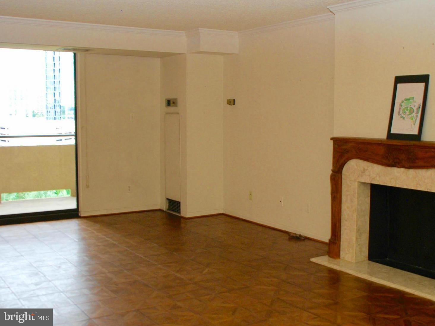 1800 Old Meadow Road, Unit 1510 McLean, VA 22102 - Photo 5 of 25 a view of an empty room with wooden floor and a fireplace