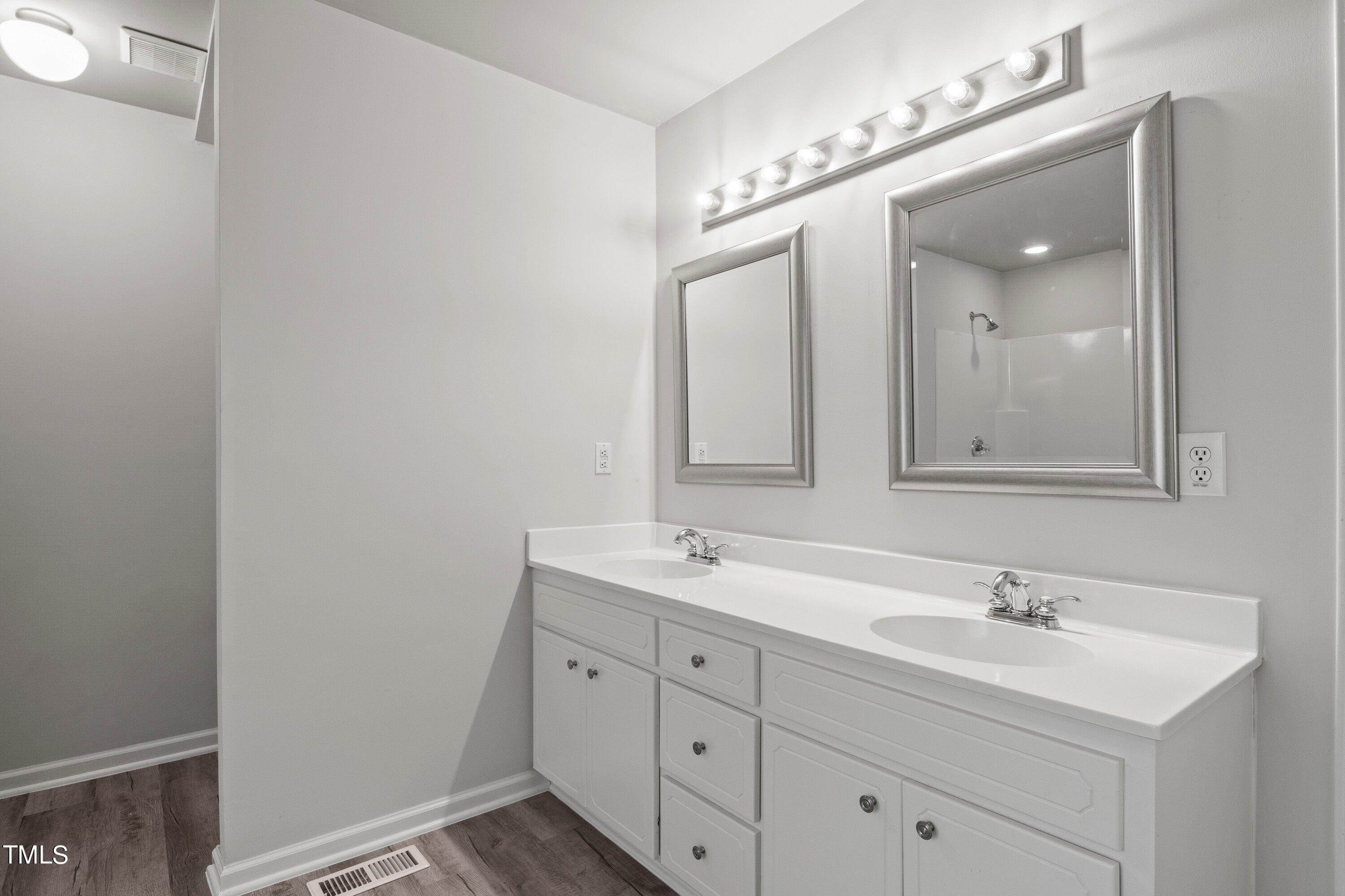 505 Castleberry Road Clayton, NC 27527 - Photo 11 of 38 a bathroom with a double vanity sink and mirror