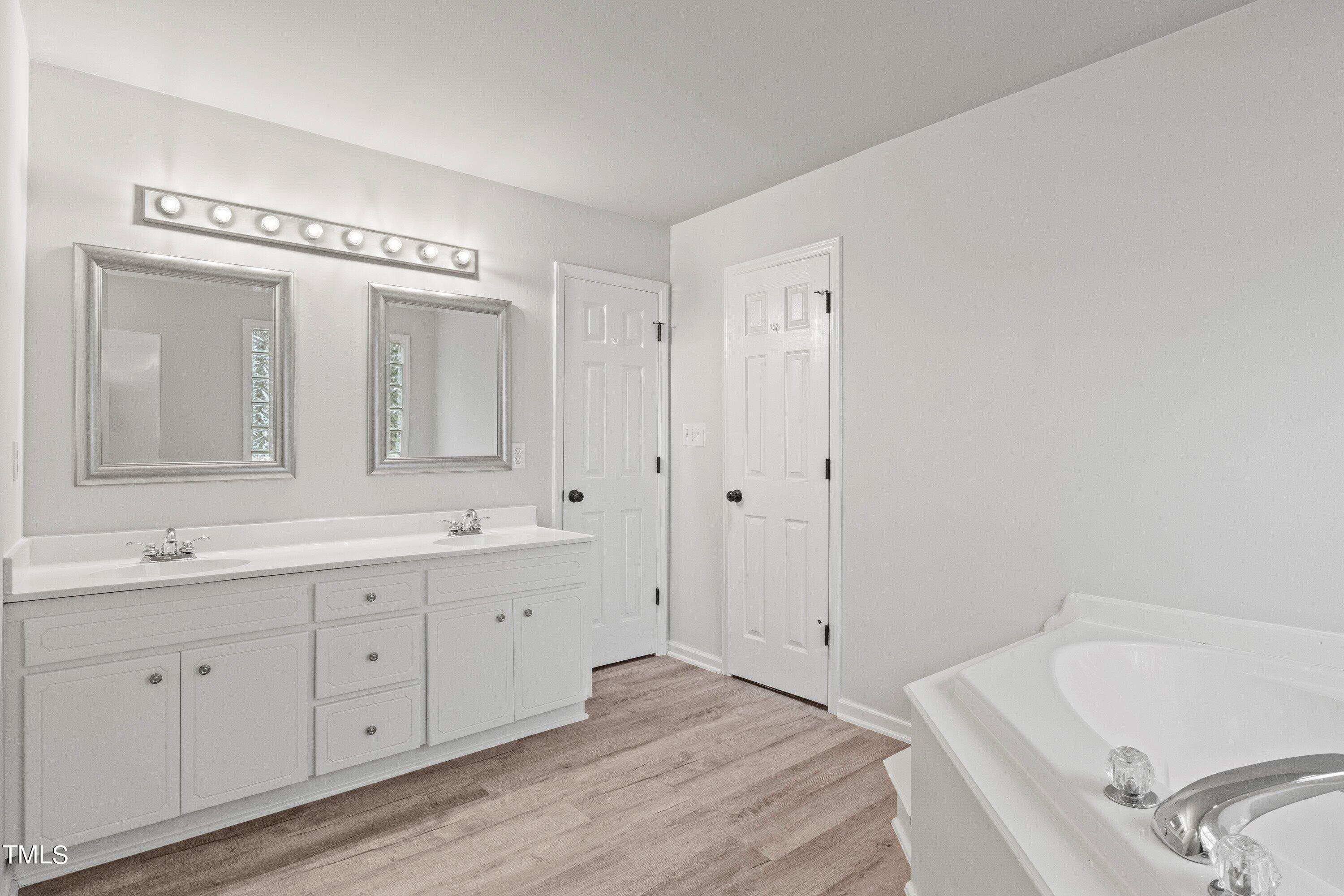 505 Castleberry Road Clayton, NC 27527 - Photo 13 of 38 a spacious bathroom with a tub sink and mirror