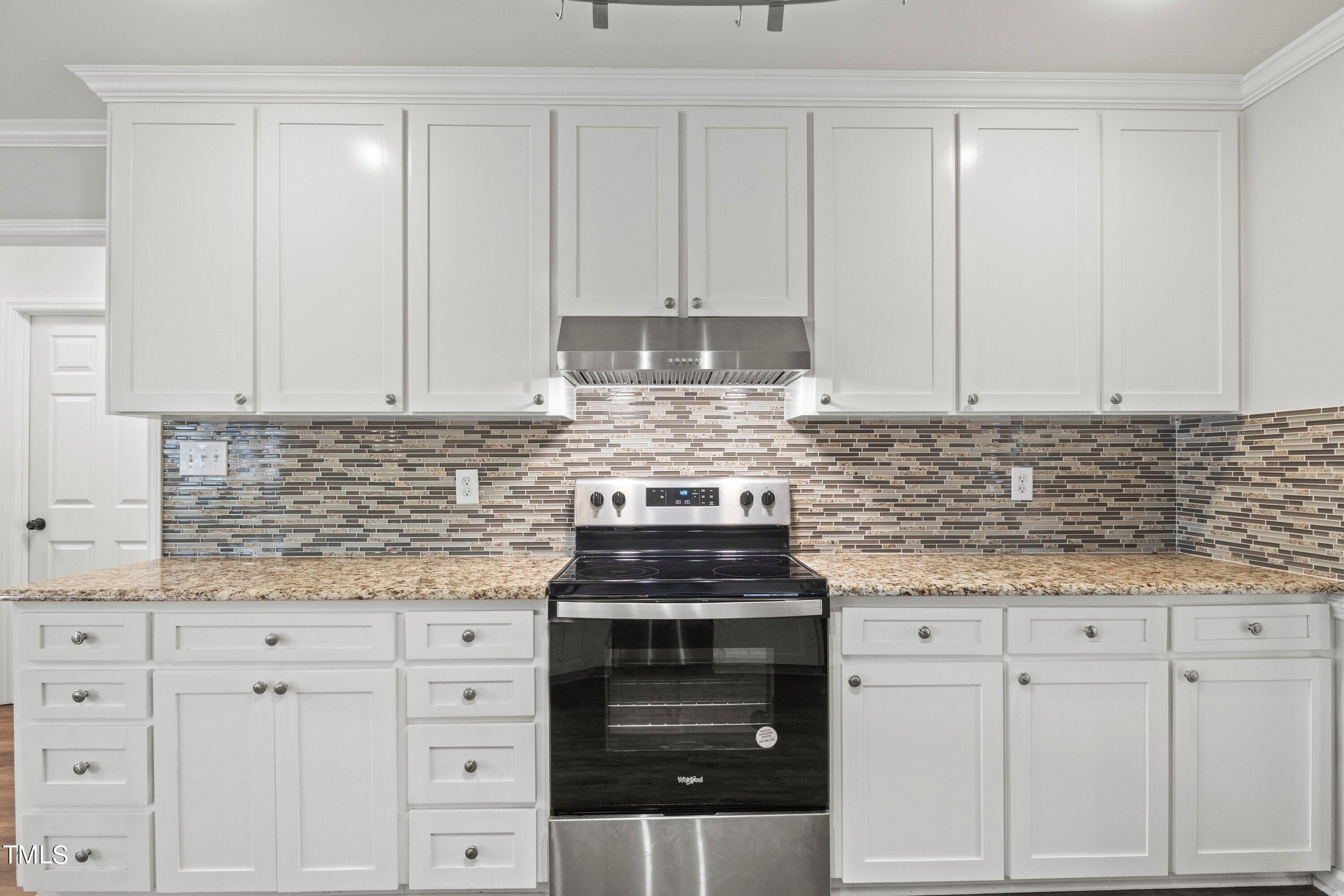 505 Castleberry Road Clayton, NC 27527 - Photo 17 of 38 a kitchen with granite countertop white cabinets and stainless steel appliances