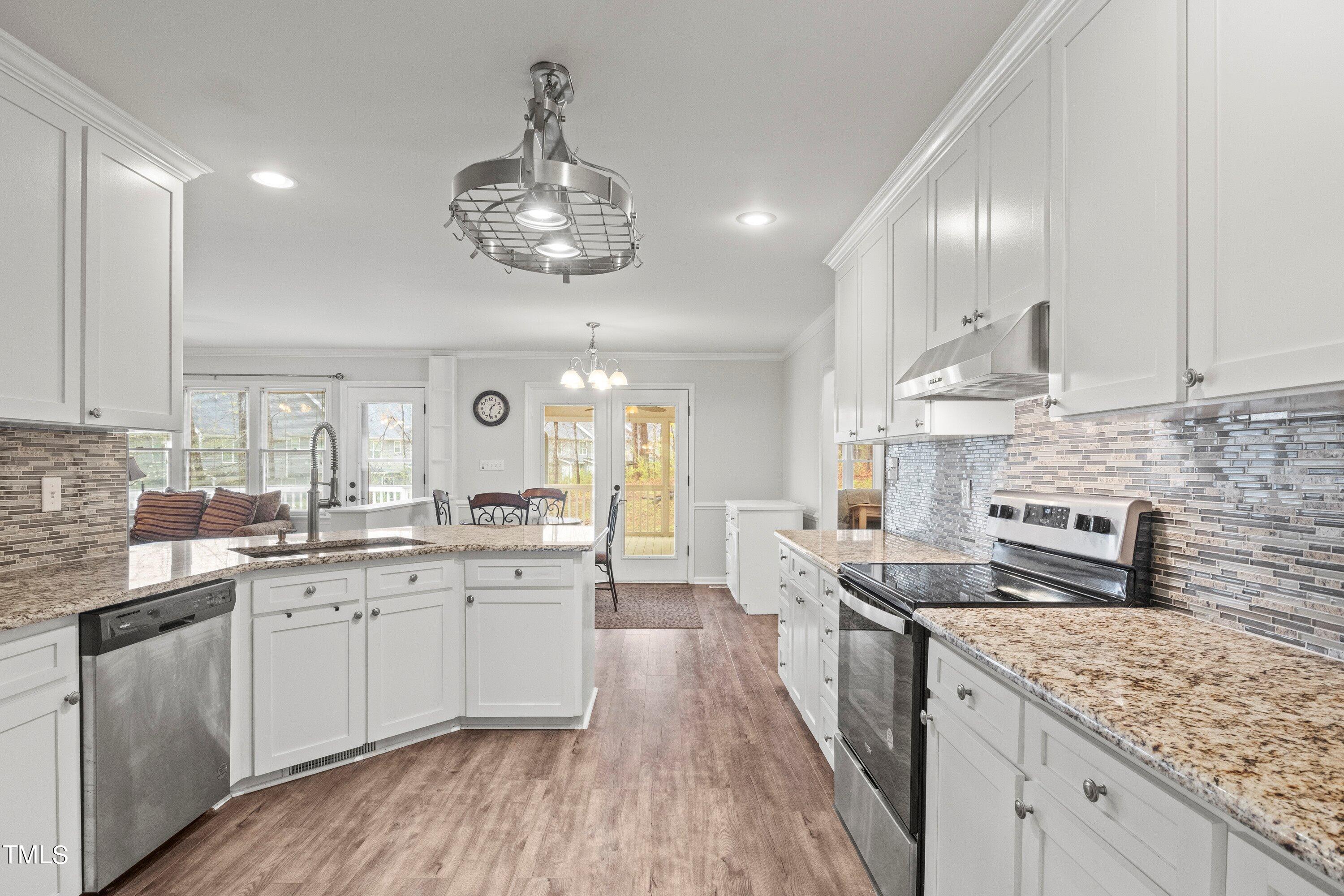 505 Castleberry Road Clayton, NC 27527 - Photo 3 of 38 a large kitchen with stainless steel appliances granite countertop a lot of counter space and wooden floor