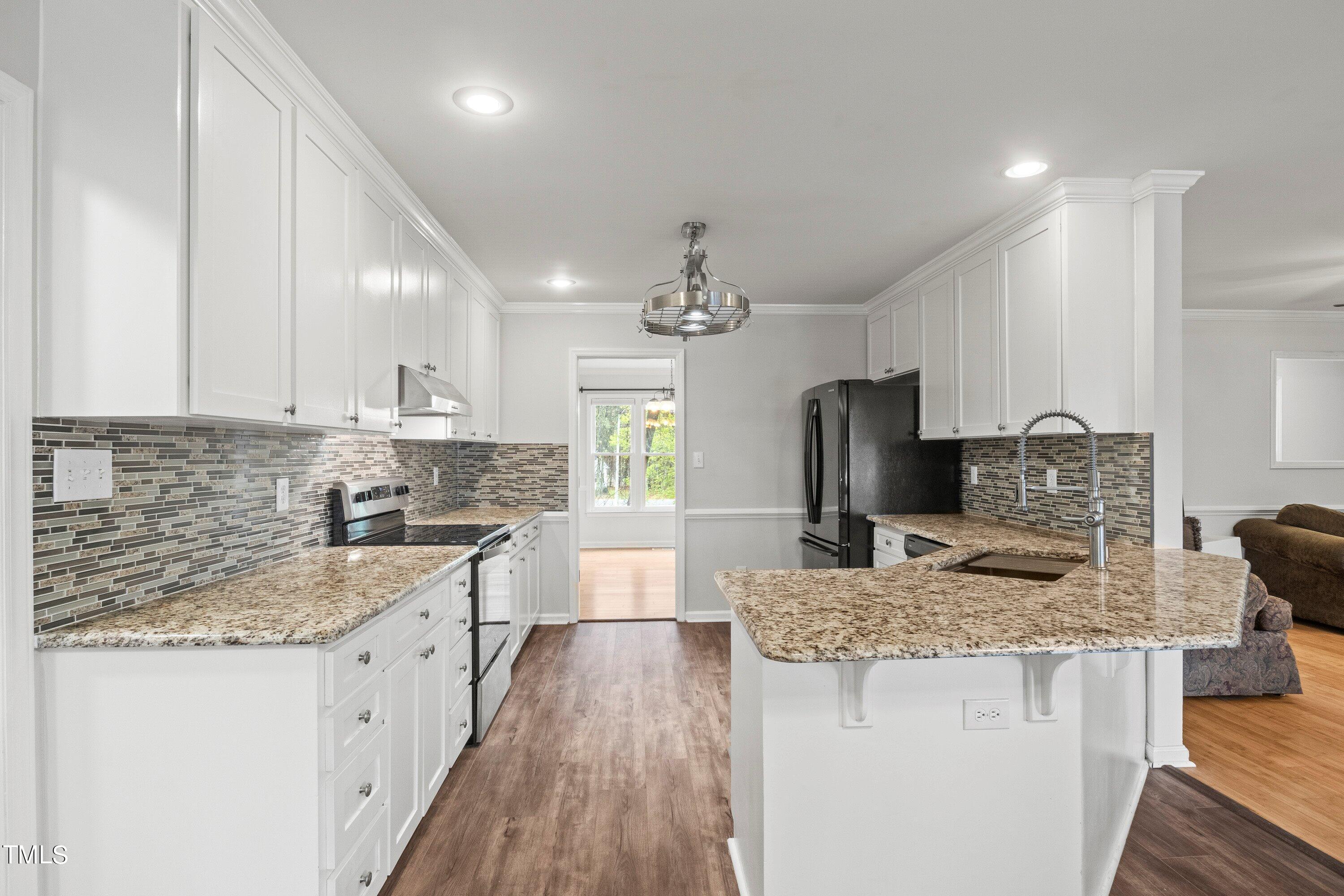 505 Castleberry Road Clayton, NC 27527 - Photo 4 of 38 a kitchen with stainless steel appliances granite countertop a sink stove and refrigerator