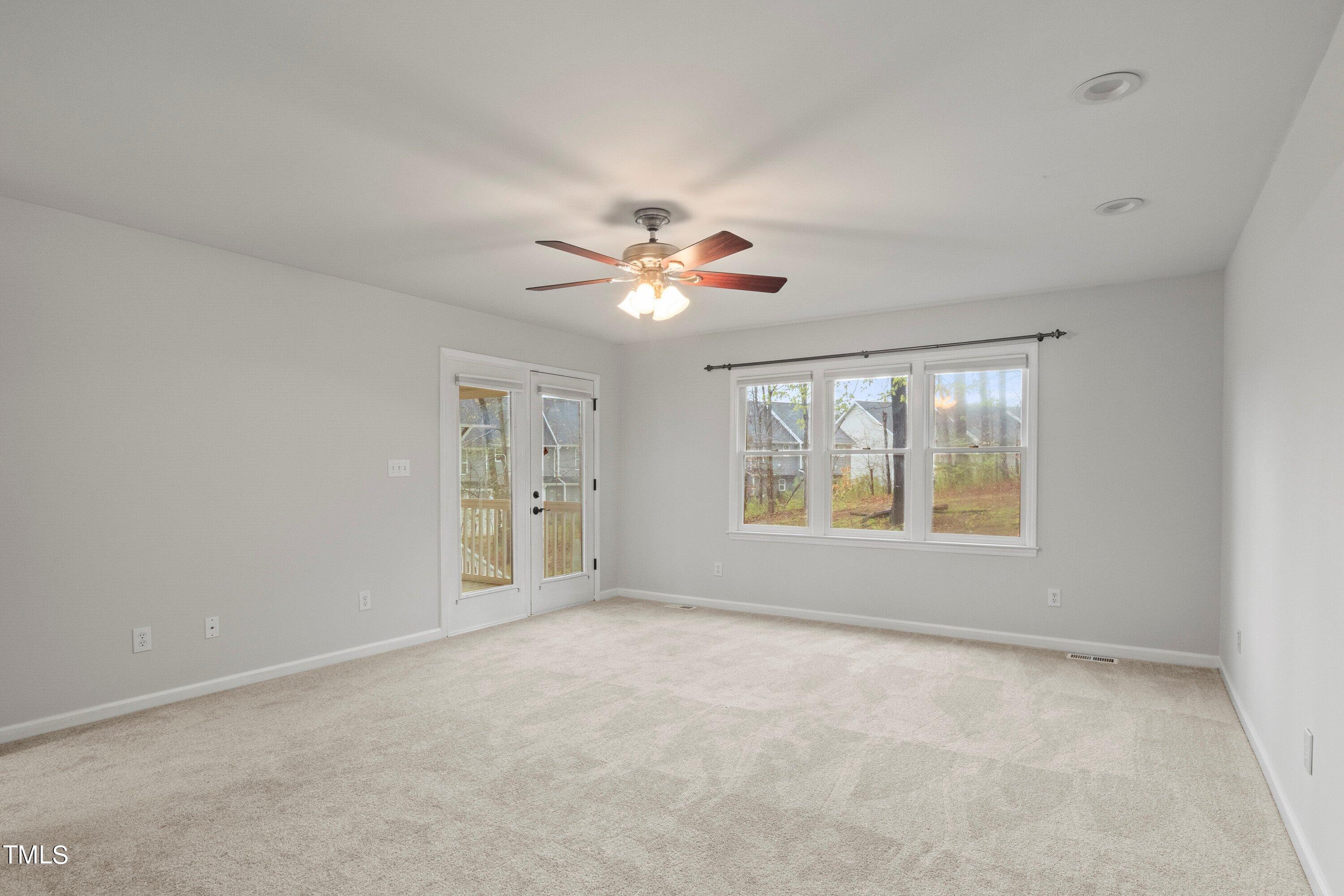 505 Castleberry Road Clayton, NC 27527 - Photo 8 of 38 an empty room with windows and chandelier fan