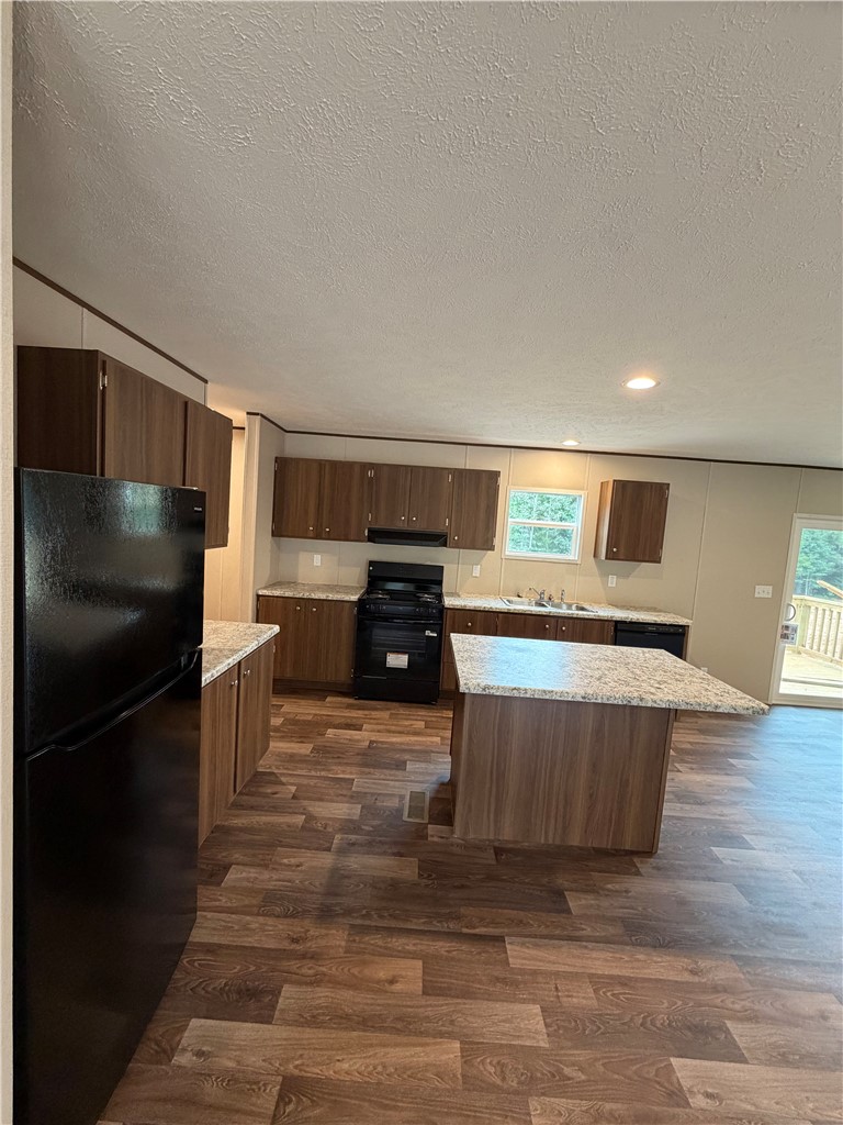 1411 Slaton Road Townville, SC 29689 - Photo 6 of 17 Rich wood-toned cabinetry and a spacious central island define this functional culinary space.
