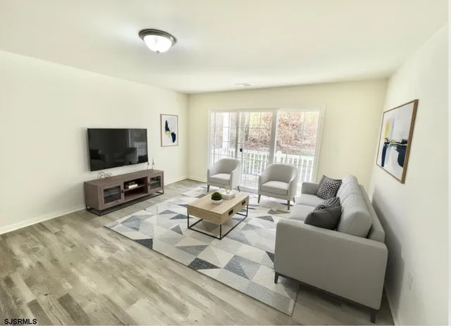 a living room with furniture a flat screen tv and a large window