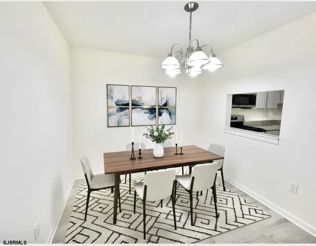a view of a dining room with furniture and a chandelier