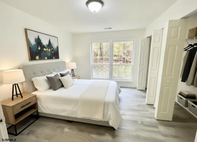 a bedroom with a bed and a large window