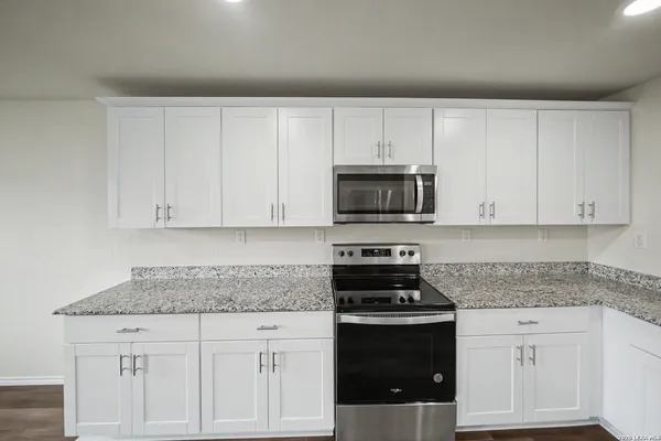 a kitchen with white cabinets and stainless steel appliances