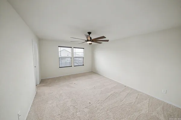 an empty room with windows and ceiling fan view