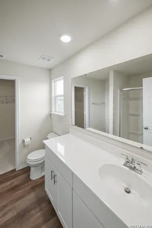 a spacious bathroom with a double vanity sink toilet and a mirror