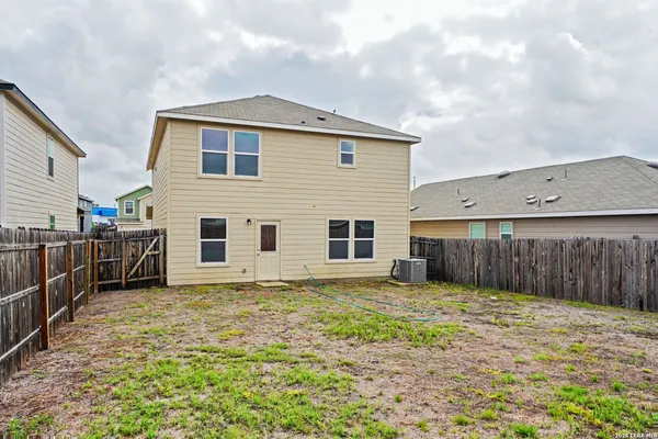 a view of a house with backyard and wooden fence