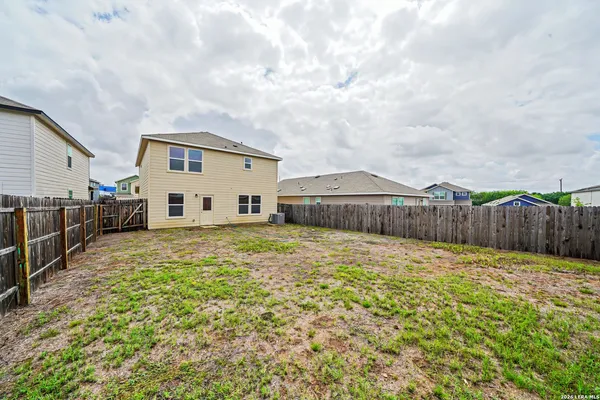 a view of a house with backyard and wooden fence