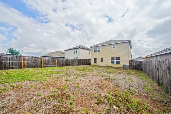 a view of a house with backyard and fence