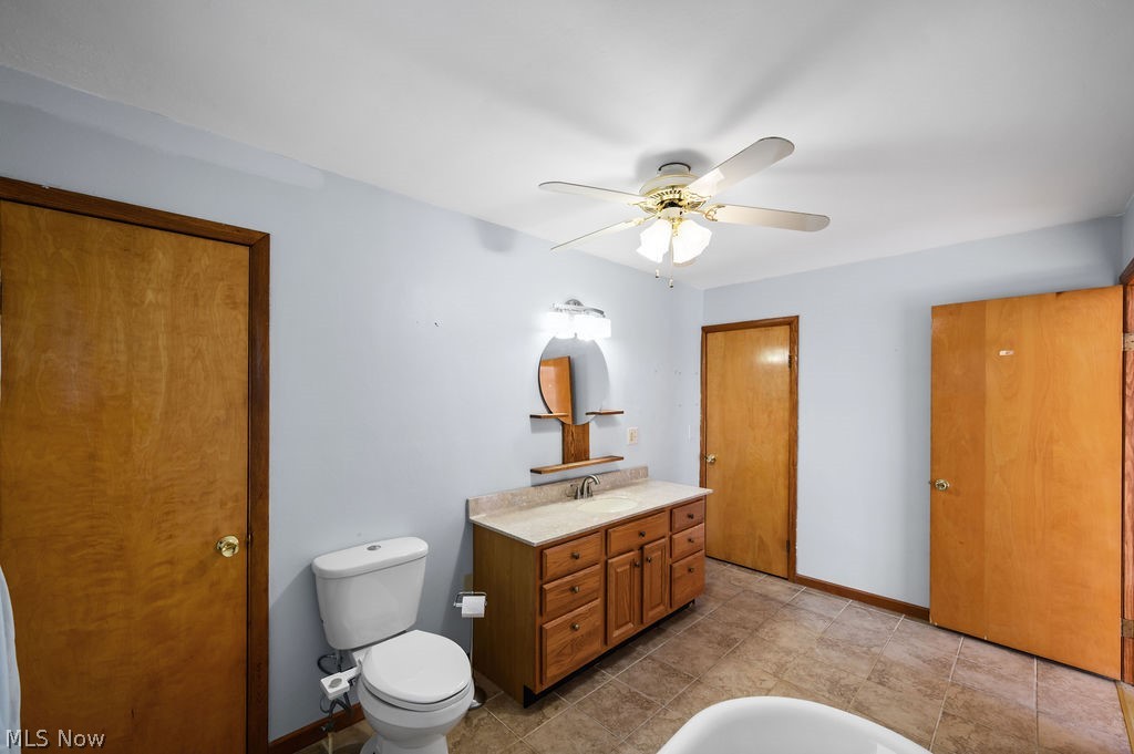 11363 Dupont Road Washington, WV 26181 - Photo 16 of 42 Wood-finish vanity with a light-colored countertop, dual-light fixture, and ceiling fan