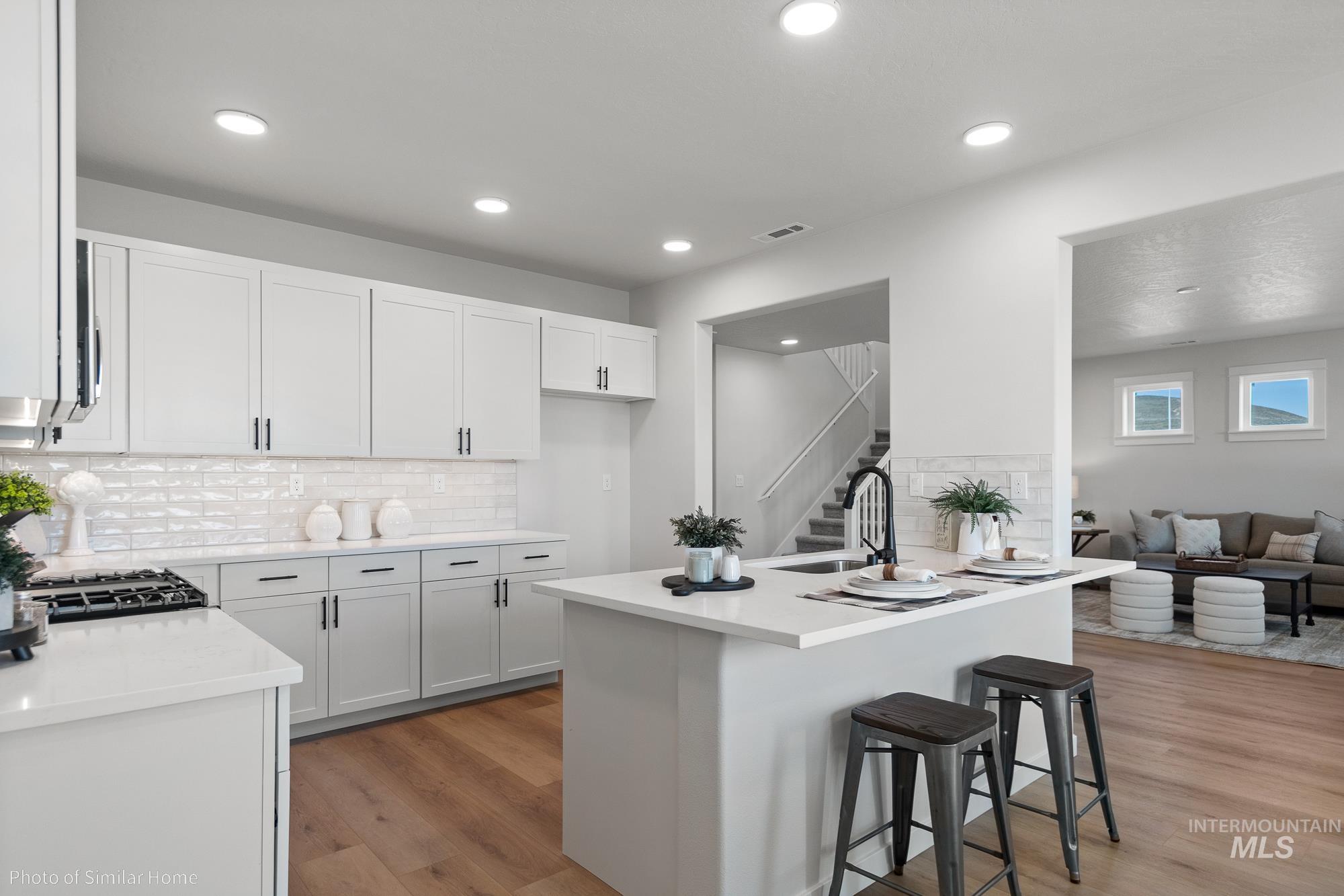 3 Tbd S Sorrel Trail Nampa, ID 83686 - Photo 3 of 17 Kitchen with a kitchen breakfast bar, light wood finished floors, white cabinets, light stone counters, and recessed lighting