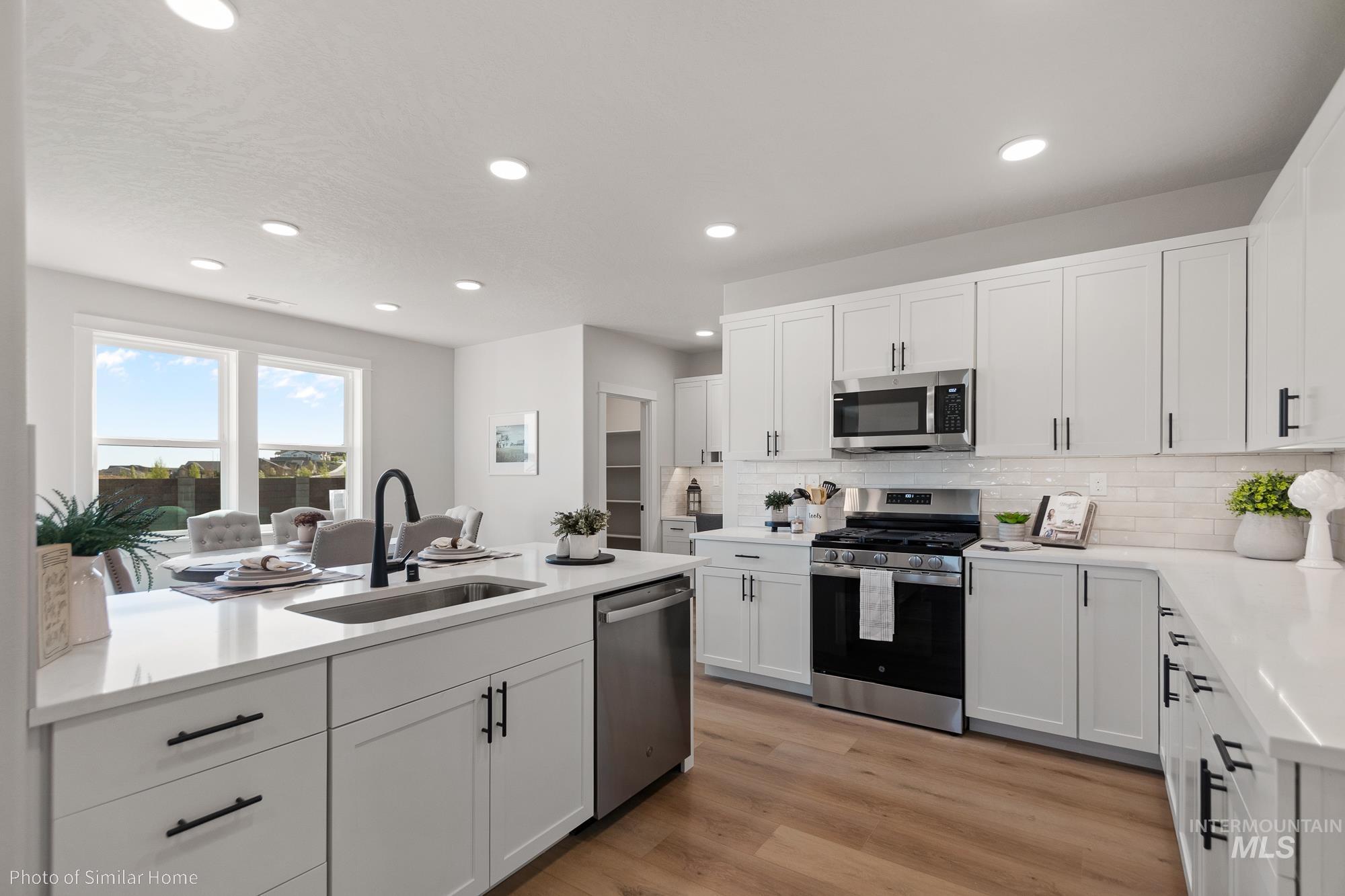 3 Tbd S Sorrel Trail Nampa, ID 83686 - Photo 4 of 17 Kitchen with stainless steel appliances, white cabinetry, light wood finished floors, decorative backsplash, and recessed lighting