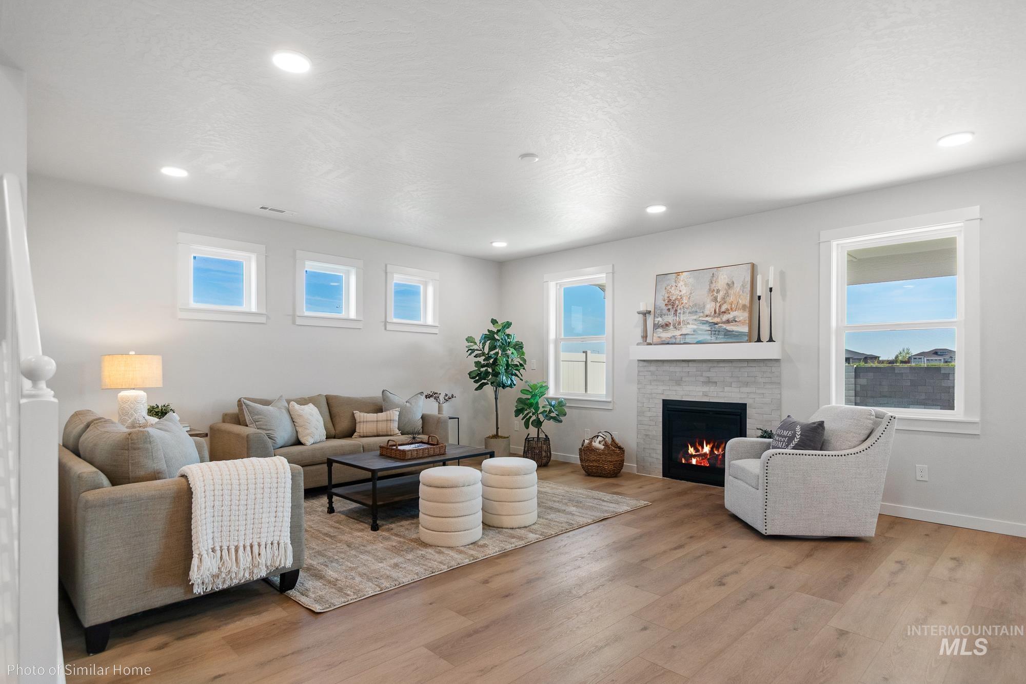 3 Tbd S Sorrel Trail Nampa, ID 83686 - Photo 5 of 17 Living area featuring light wood-style flooring, a lit fireplace, and recessed lighting