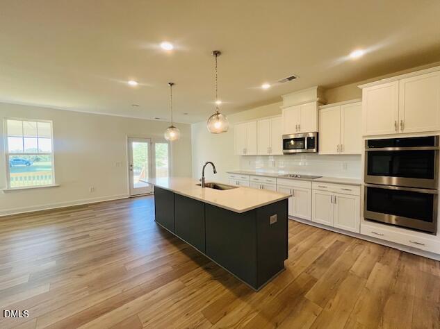 49 Alden Way Angier, NC 27501 - Photo 27 of 66 a large kitchen with stainless steel appliances granite countertop a stove a sink and a microwave