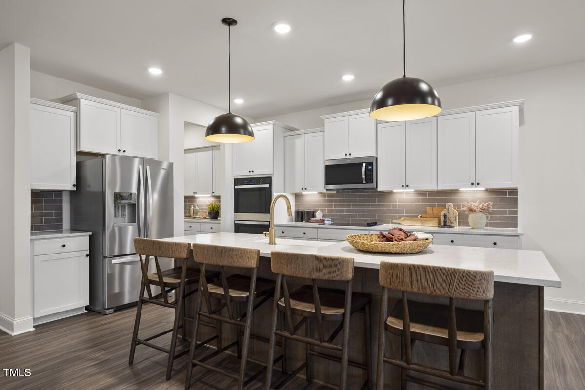 49 Alden Way Angier, NC 27501 - Photo 10 of 66 a kitchen with a dining table chairs stainless steel appliances and cabinets